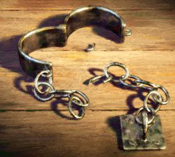Prisoners chain broken open laying on wooden table